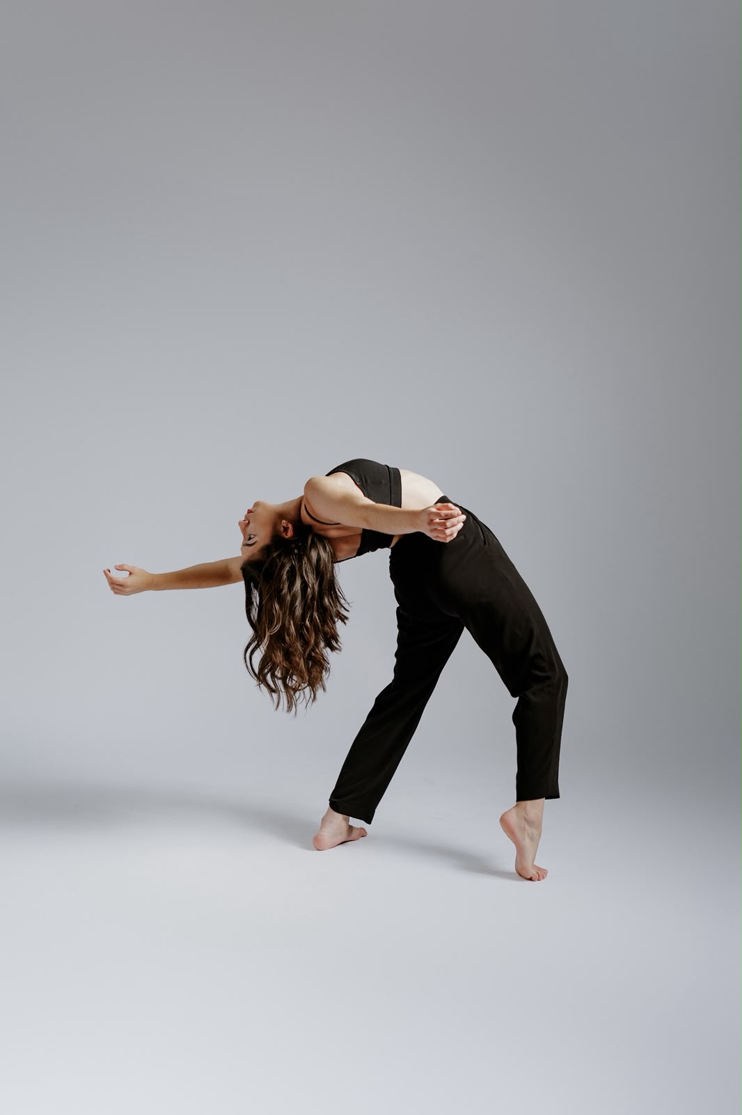 Dancer performing an expressive backbend with arms extended